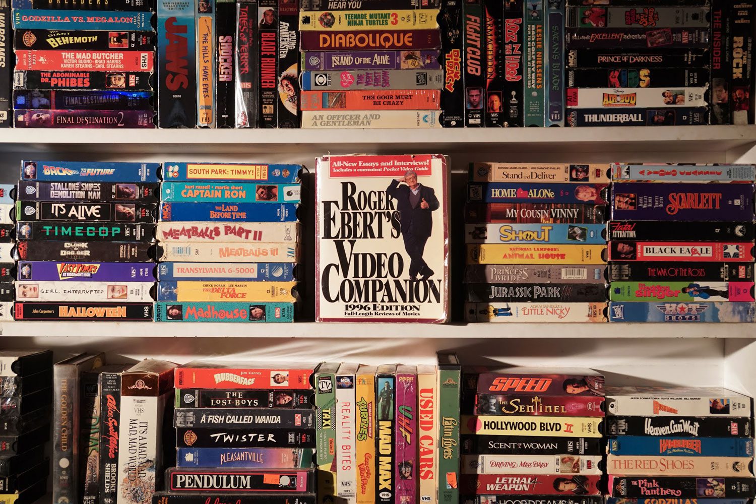 three levels of fully stocked shelves of dvds and vhs tapes